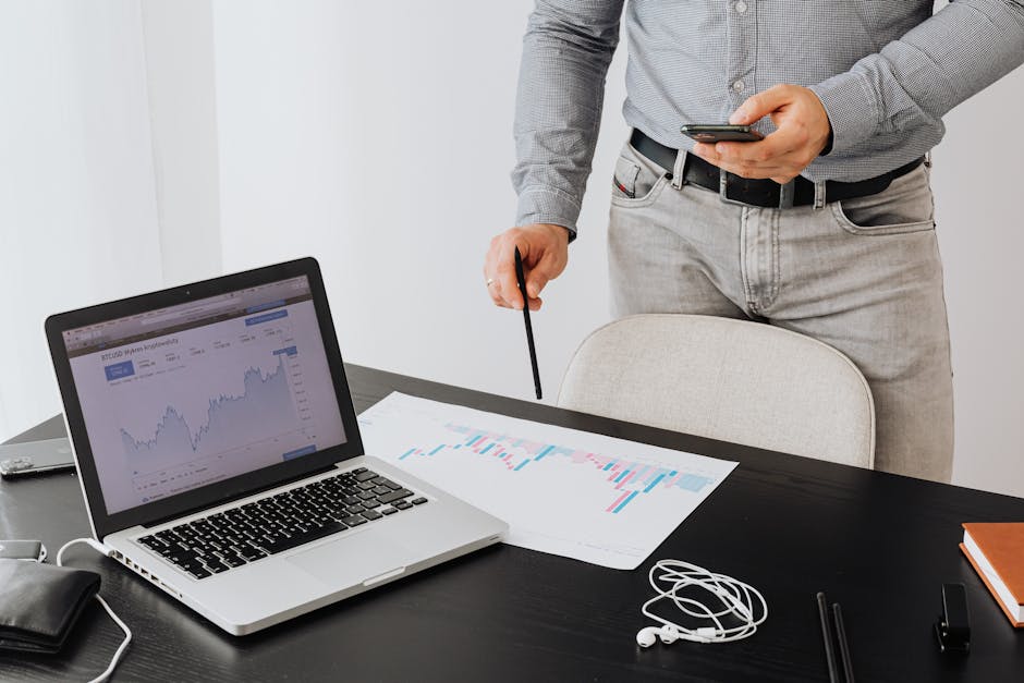 Business professional analyzing cryptocurrency trends on a laptop with graphs and charts.