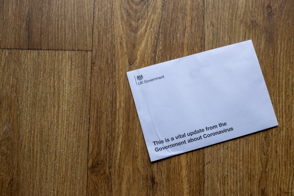 A UK Government envelope with coronavirus update on a wooden floor.